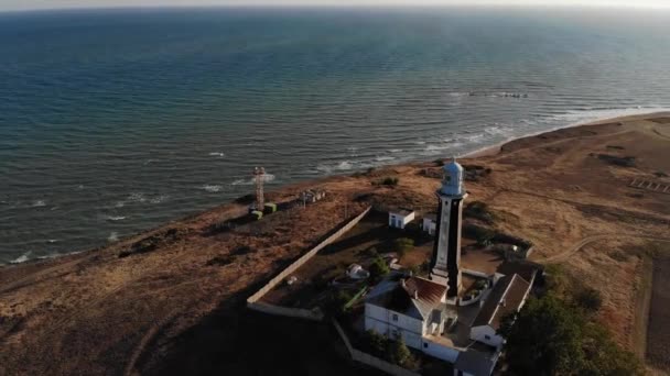 Vista aérea do farol marítimo costeiro fica à beira-mar ou oceano. Edifícios históricos para fins especiais — Vídeo de Stock