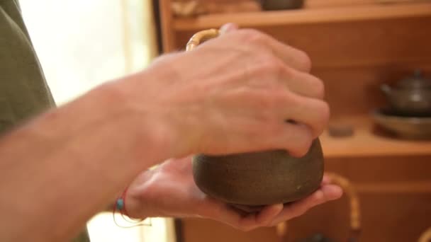 Egy férfi fazekas bemutatja a munkáját Yixing agyag teáskanna egy kézzel készített teaszertartásra a közelben. Sekély mélységélesség — Stock videók