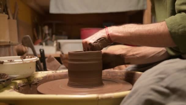 A male potter makes clay dishes on a potters wheel. Craft production of devices for tea cerimonium — Stock Video