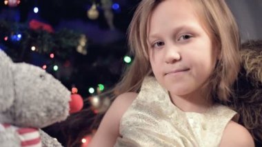 Pembe elbiseli küçük bir kız oyuncağına bakıyor. Bozuk tatil. Düşünceli bir çocuk.