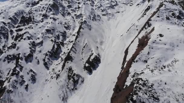 Légi kilátás hófödte meredek lejtők. Keskeny kupon extrém freeride és backcountry síelés magas a hegyekben — Stock videók