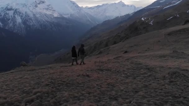 Aerial view of a man and a woman walking high in the mountains and admiring the view. Mountain sports trekking — Stock Video