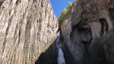 Dağlardaki kayaların arasında yavaş çekim büyük şelale. Küresel ısınma ve dünyadaki su miktarının düzenlenmesi