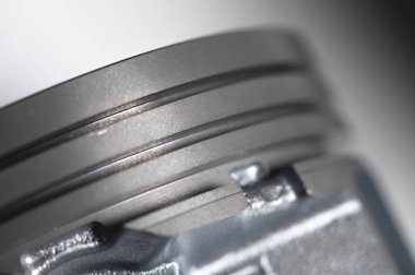 Gri arkaplandaki içten yanmalı motorun yakın çekim pistonu. Motor tamiri için yeni yedek parça. Arkaplanı onar