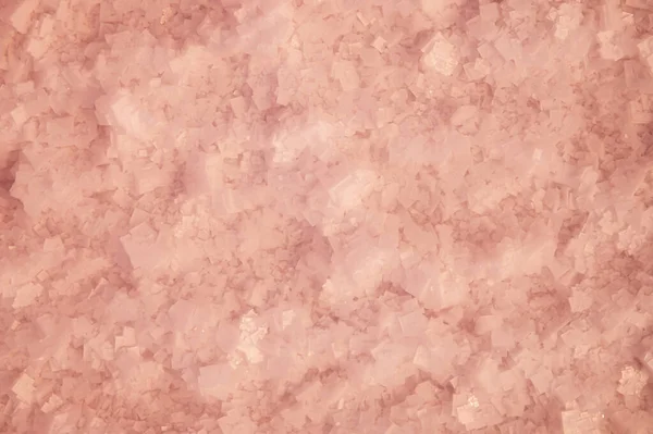 Krystaly růžové soli na dně jezera skrz růžovou vodu. Solné pozadí v defokusu — Stock fotografie