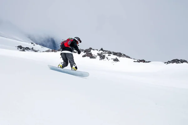 Woman snowboarder has fun riding on snowy off-road freeride in the Italian Alps. Professional sportswoman snowboard freeride — Stock Photo, Image