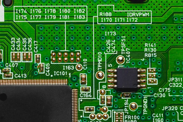 Microchip de primer plano de circuito electrónico en un microcircuito verde con elementos de transistores y flejes —  Fotos de Stock