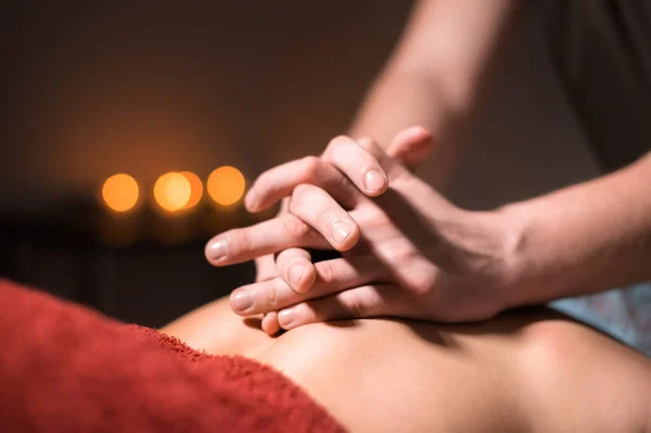 Manlig massör gör rygg massage till klient kvinna i mörkt rum massage spa — Stockfoto