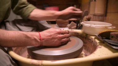 Erkek bir çömlekçi çömlekçi çarkında kil yemekleri yapar. Çay seremonyumu için cihaz üretimi