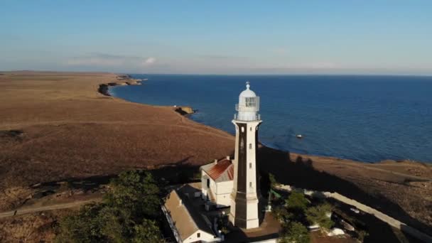 Flygfoto över den kustnära havsfyren står på stranden eller havet. Historiska byggnader för speciella ändamål — Stockvideo