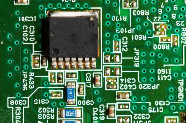 Elektronik devre, transistör elementleri ve kayışlı yeşil bir mikroçip üzerinde.