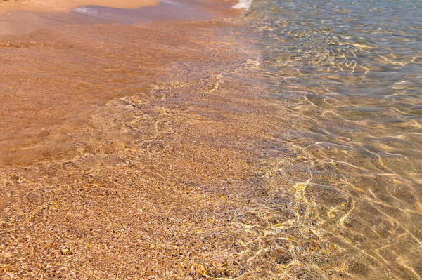 Ruhiger morgendlicher Meeresstrand mit kleinen Wellen mit Schaum und klarem Wasser — Stockfoto