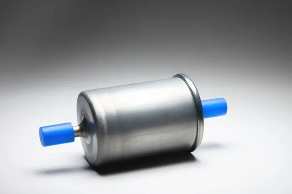 Новый топливный фильтр для двигателя внутреннего сгорания бензина с голубыми колпачками на сером фоне. Новые запасные части — стоковое фото