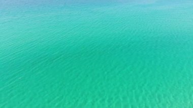 Turkuaz deniz suyunun yüksek irtifa mavi gök mavisi dokusundan havadan aşağıya doğru görüntüsü. Su yüzeyinin manzarası. Su yüzeyi arkaplanı.