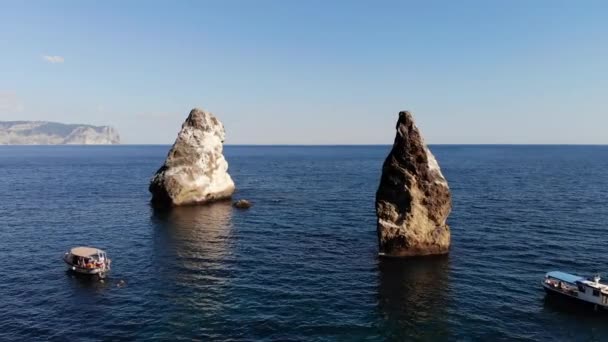 Vista aérea de barcos turísticos en la bahía de mar junto a rocas individuales y alta costa rocosa. Vacaciones mediterráneas de lujo — Vídeo de stock