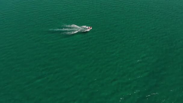 Körfezdeki küçük bir sürat teknesinin havadan görüntüsü. Açık deniz taşımacılığı üst görüntü. Turkuaz suyun tropikal körfezinin inanılmaz manzarası. — Stok video