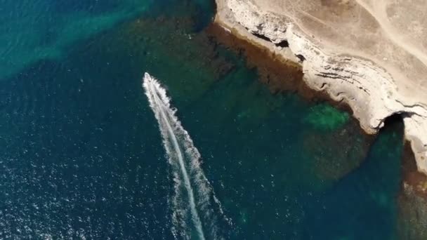 Vista aérea de una pequeña lancha rápida en la bahía. Vista superior del transporte de agua ligera. Increíble vista de la bahía tropical de agua turquesa — Vídeo de stock