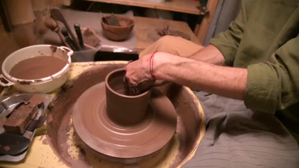 Um oleiro macho faz pratos de barro em uma roda de oleiros. Produção artesanal de dispositivos para cerimônio do chá — Vídeo de Stock