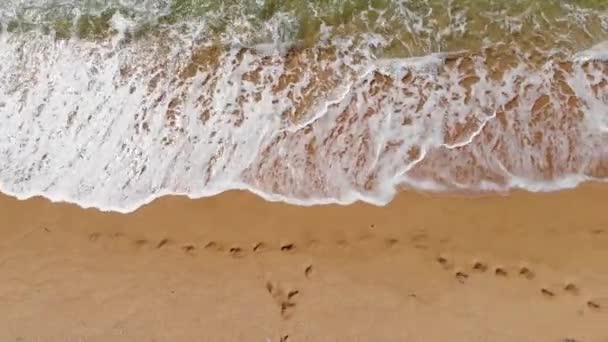 Вид зверху на океанські блакитні хвилі, що падають на пляж. Морські хвилі і красивий піщаний пляж вид з повітря, знятий з дрона . — стокове відео