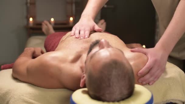 Masaje de cerca del músculo pectoral al atleta el cliente está haciendo un masajista masculino — Vídeo de stock
