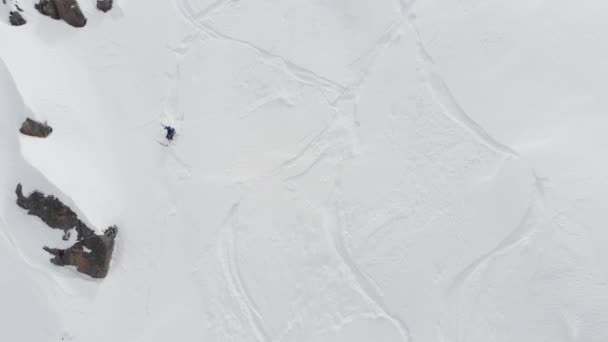 Vue aérienne d'un athlète masculin grimpant une pente raide vers le haut. Skitour freeride backcountry escalade avec des skis à travers la neige haute dans les montagnes du Caucase du Nord — Video