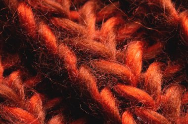 Kırmızı-turuncu örgü arka plan dokusu. Örgü dikişlere yakın çekim. Makro