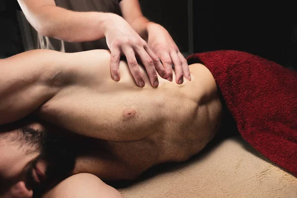 Professional sports massage of the lumbar region for a man to an athlete in a professional massage salon — Stock Photo, Image