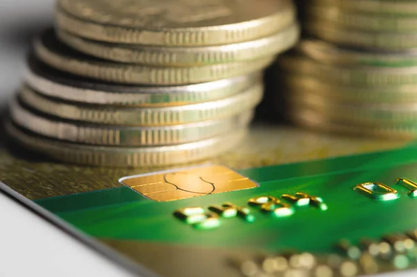 Close-up shallow depth of field credit card with microchip on the background of columns of metallic coins
