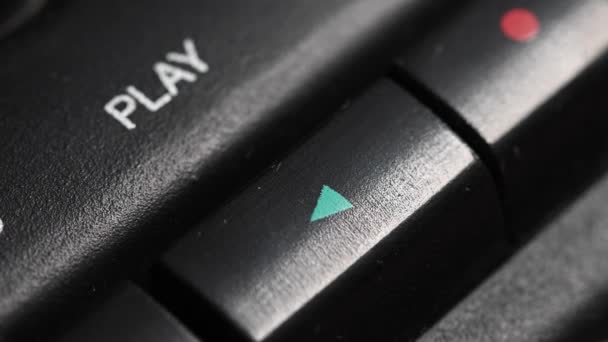 Ondiepe scherptediepte van dichtbij. Een mensenvinger drukt op een knop om op een oude bandrecorder af te spelen. Speel een liedje. — Stockvideo