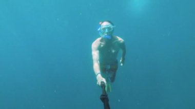 Harika bir yüzücü olan atletik beyaz bir erkek tarafından çekilen sualtı selfie 'si. Deniz ya da okyanus tarafından serbest dalış ve rahatlama kavramı
