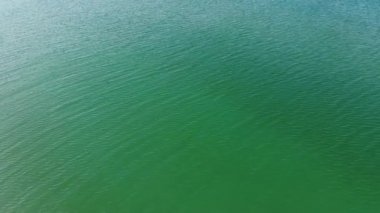 Turkuaz deniz suyunun yüksek irtifa mavi gök mavisi dokusundan havadan aşağıya doğru görüntüsü. Su yüzeyinin manzarası. Su yüzeyi arkaplanı.