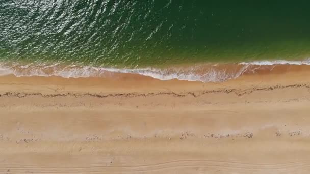 Vista aérea superior das ondas azuis do oceano que caem na praia. Ondas do mar e bela praia de areia vista aérea tiro de um drone. — Vídeo de Stock