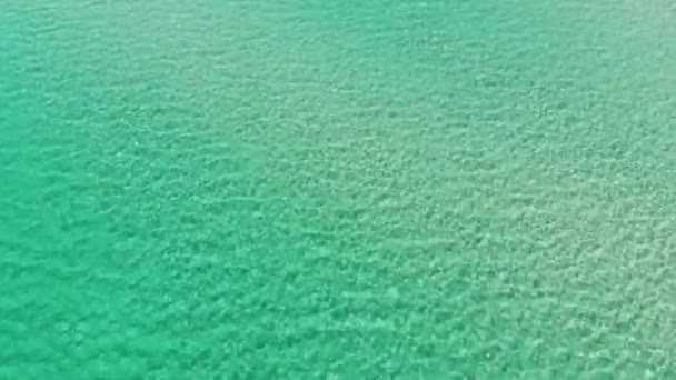 Luftaufnahme von oben aus großer Höhe mit blauer azurblauer Textur aus türkisfarbenem Meerwasser. Blick auf die Wasseroberfläche. Hintergrund der Wasseroberfläche. — Stockvideo