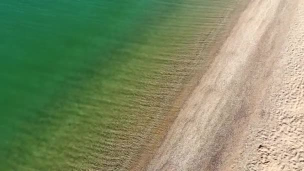 Vista aerea dall'alto delle onde blu oceano che si infrangono sulla spiaggia. Onde marine e bella spiaggia sabbiosa vista aerea girato da un drone. — Video Stock