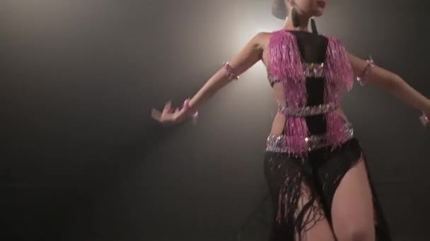 Attraente giovane ragazza che balla assolo latino in una stanza buia con fumo in un tasto basso. Professionale sala da ballo danza sportiva 4k — Video Stock