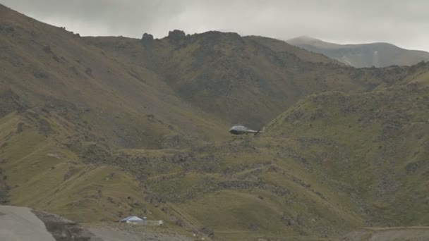 Blå uidentificeret helikopter flyver i overskyet vejr i bjergene – Stock-video