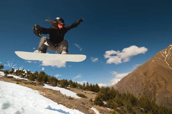 Kobieta sportowiec snowboarder leci po skoku z kicker robi sztuczkę — Zdjęcie stockowe