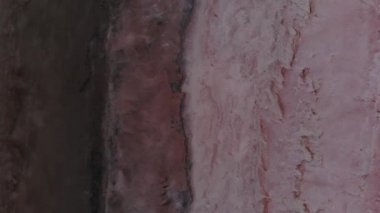 Havadan aşağıya doğru eğilmiş Pembe Tuz Gölü alçak anahtarı. Sinematik film tahılları. Akşam çekimi.