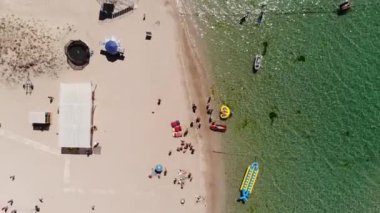 Orta Asya 'nın gökyüzü manzarası, dinlenen turistler ve plaj şemsiyeleri. Deniz kenarında turizm ve eğlence için arka plan