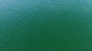Turkuaz deniz suyunun yüksek irtifa mavi gök mavisi dokusundan havadan aşağıya doğru görüntüsü. Su yüzeyinin manzarası. Su yüzeyi arkaplanı.