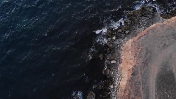 Вид з повітря на круту скелясту берегову лінію. Море під час шторму з хвилями і піною — стокове відео