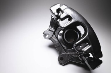 Siyah fren kalibreli. Gri zemin üzerinde yüksek kontrastlı bir araba fren sistemi için yedek parça.