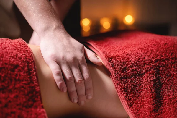 Male masseur doing back massage to client woman in dark room of massage spa — Stock Photo, Image