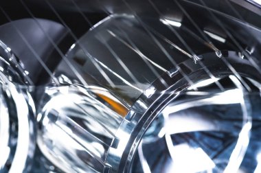 Makro yakın çekim faktörü, farı fıskiyedeki yeni farın yansıtıcısı. Yumuşak odaklı araba arkaplanı