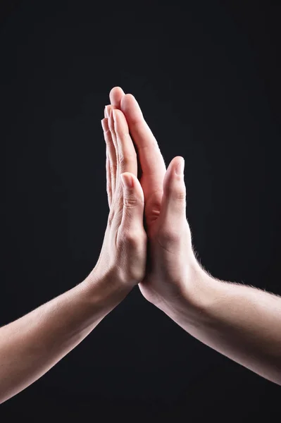 High five male and female hand gesture on black background. Friendship of men with women — Stock Photo, Image