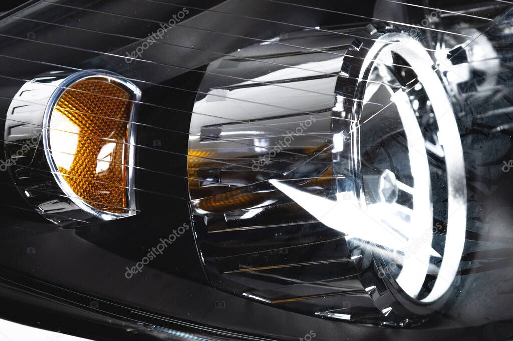 Close-up detail of shiny car headlight reflector with turn signal repeater element