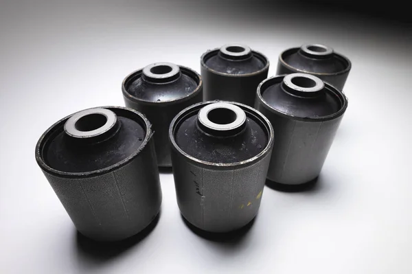 Close-up wide angle. A group of cylindrical silent blocks for the rear suspension of an off-road vehicle. Contrast light low key — Stock Photo, Image