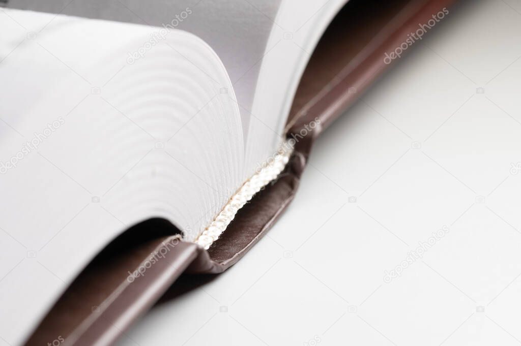 Close-up of the hardback of a thick book on a gray background. Reading and libraries