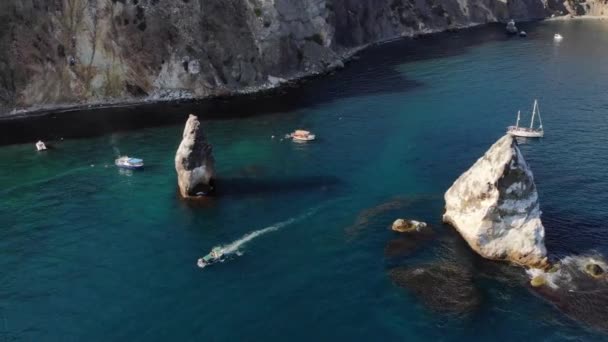 Luchtfoto van toeristische boten in de baai naast individuele rotsen en hoge rotsachtige kust. Luxe mediterrane vakanties — Stockvideo