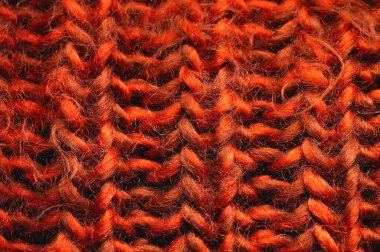 Kırmızı-turuncu örgü arka plan dokusu. Örgü dikişlere yakın çekim. Makro